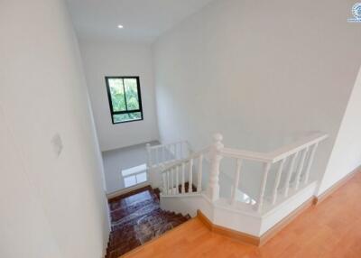 Bright and clean staircase area with a small window and wooden stairs