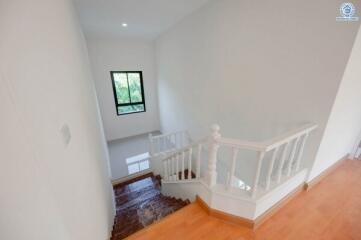 Bright and clean staircase area with a small window and wooden stairs