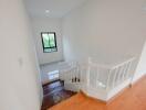 Bright and clean staircase area with a small window and wooden stairs