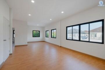 Spacious and bright living room with large windows and hardwood floors