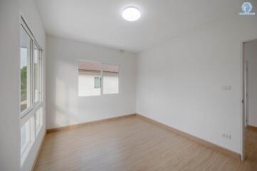 Spacious unfurnished bedroom with large windows and hardwood floors