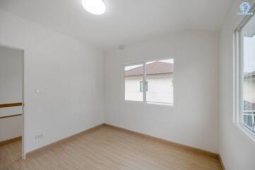 Bright and spacious empty bedroom with wooden flooring