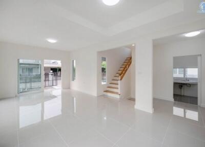 Spacious and bright living room with tiled flooring and easy access to staircase