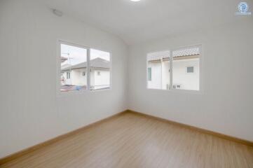 Bright and spacious empty bedroom with two windows