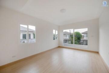 Spacious empty living room with large windows and hardwood floors