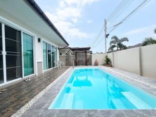 Elegant outdoor swimming pool adjacent to a modern residential home