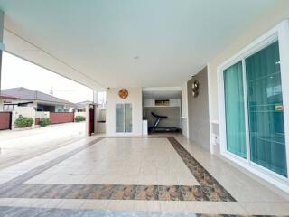 Spacious covered patio with stylish tile flooring and comfortable seating area