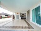 Spacious covered patio with stylish tile flooring and comfortable seating area