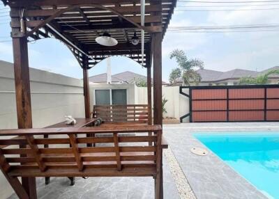 Spacious backyard with swimming pool and wooden gazebo