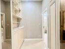 Spacious white hallway with built-in shelves and modern lighting