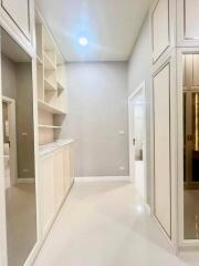 Spacious white hallway with built-in shelves and modern lighting