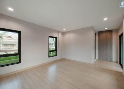 Spacious and well-lit living room with wooden floors and large windows