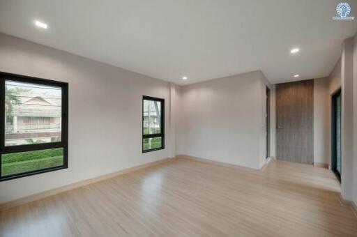 Spacious and well-lit living room with wooden floors and large windows