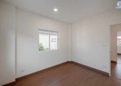 Bright and spacious empty bedroom with wooden flooring and large windows