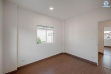 Bright and spacious empty bedroom with wooden flooring and large windows