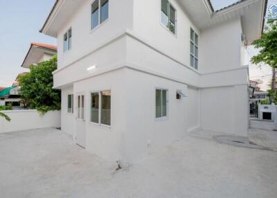 Modern white two-story house with a spacious front yard