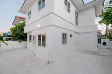 Modern white two-story house with a spacious front yard