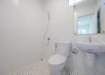 Modern white bathroom with wall-mounted sink and toilet