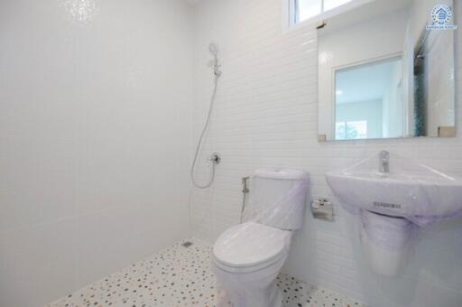 Modern white bathroom with wall-mounted sink and toilet