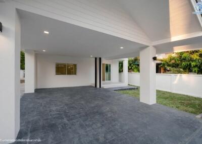 Modern covered patio area with open sliding doors and garden view