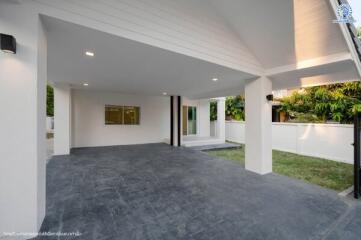 Modern covered patio area with open sliding doors and garden view