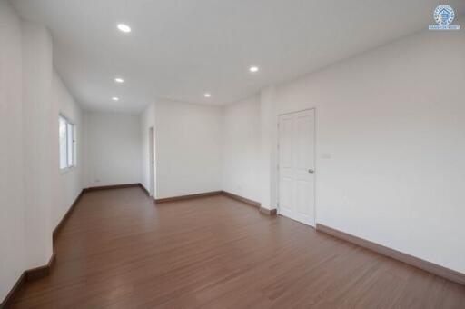 Spacious empty living room with wooden floors and white walls