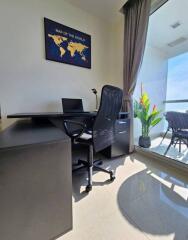 Spacious and well-lit home office with world map artwork and balcony view
