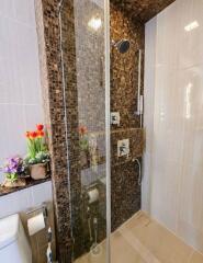 Modern bathroom with glass shower enclosure and decorative tiles