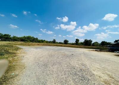 Expansive outdoor vacant lot with clear blue sky and scattered clouds