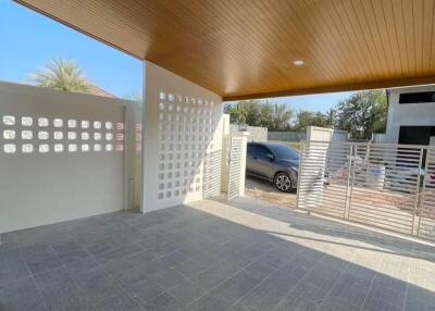 Spacious modern carport with decorative wall and wooden ceiling