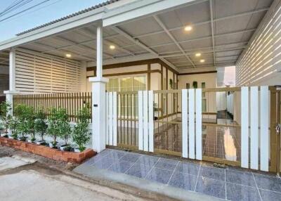 Elegant residential house front view showcasing carport and gated entrance