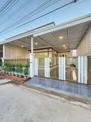 Elegant residential house front view showcasing carport and gated entrance