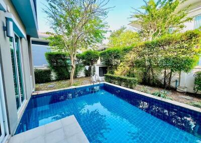 Outdoor swimming pool at residential property surrounded by lush greenery