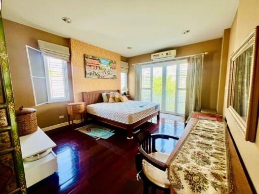 Spacious bedroom with modern furnishings and hardwood floors