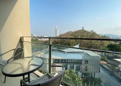 Spacious balcony with scenic city and mountain views, featuring outdoor furniture