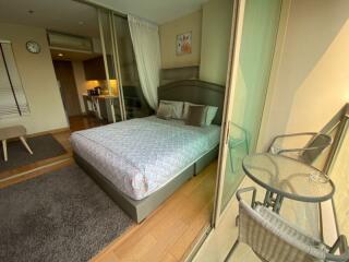 Well-lit bedroom with balcony access and modern furnishings