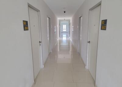 White tiled corridor in a modern building with multiple closed doors