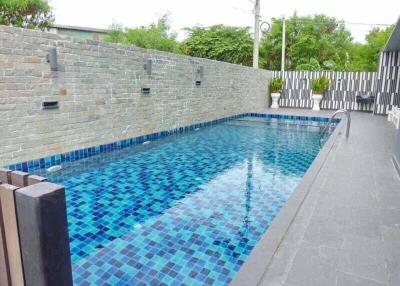 Modern outdoor swimming pool with tiled walls and floor