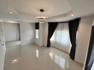 Spacious and modern living room with glossy tiled flooring and elegant drapery