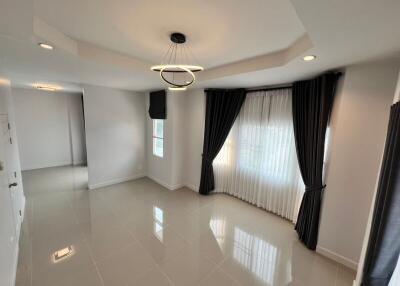 Spacious and modern living room with glossy tiled flooring and elegant drapery