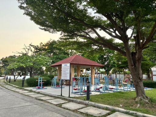 Outdoor fitness area in a residential community with exercise equipment and shaded pavilion