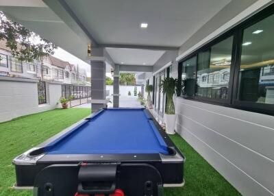 Spacious outdoor area with pool table and modern architecture