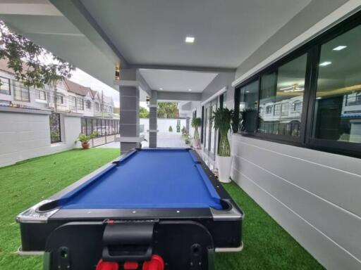 Spacious outdoor area with pool table and modern architecture