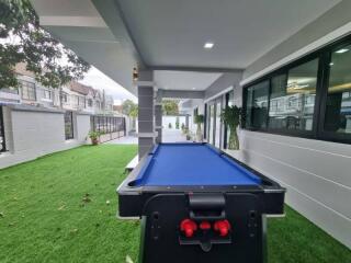 Outdoor area with a pool table on artificial grass