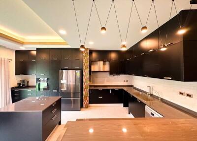 Modern spacious kitchen with elegant lighting and sleek black cabinetry