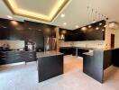Modern spacious kitchen with black cabinets and pendant lighting