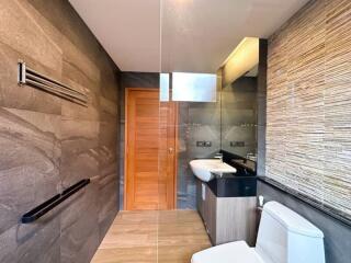 Modern bathroom with stone tiles and sleek fixtures
