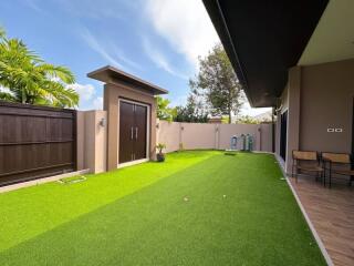 Well-maintained backyard with artificial grass and privacy fence