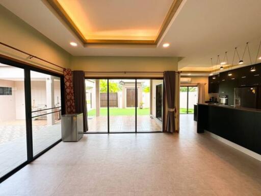 Spacious open-plan living room and kitchen with modern lighting and large sliding glass doors