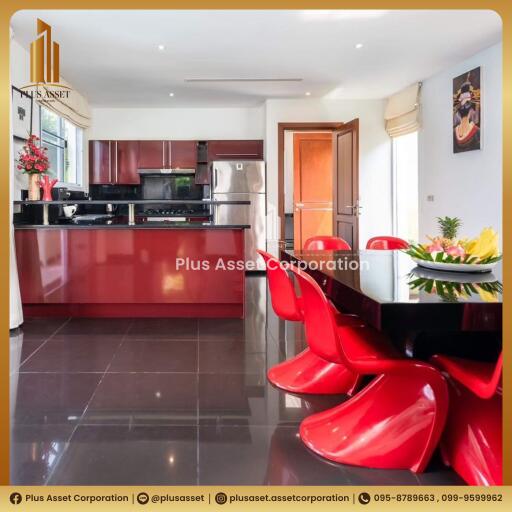 Modern kitchen with red chairs and sleek appliances